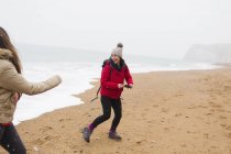 Грайлива мати і дочка на зимовому океані пляжі — стокове фото