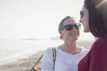 Liebevolles lesbisches Paar am sonnigen Strand — Stockfoto