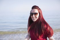 Портрет улыбающейся, уверенной женщины на солнечном пляже океана — стоковое фото