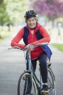 Портрет усміхнений, впевнена активна старша жінка їде на велосипеді в парку — стокове фото