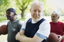 Portrait confident active senior man playing basketball with friends — Stock Photo
