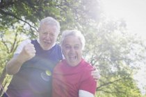 Portrait exuberant active senior men cheering in sunny park — Stock Photo