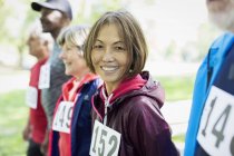 Retrato sorrindo, mulher sênior ativo confiante na linha de partida de corrida esportiva — Fotografia de Stock