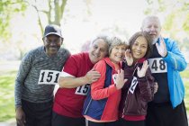 Selbstbewusste aktive Senioren-Läuferfreunde tragen sportliche Startnummern — Stockfoto