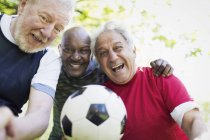 Retrato activo hombres mayores amigos jugando fútbol - foto de stock