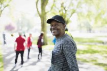 Portrait confident, happy senior man walking sports race in park — Stock Photo