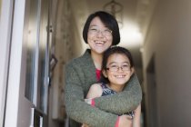 Porträt glücklich, liebevolle Mutter und Tochter umarmen sich in Tür — Stockfoto