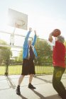 Hombres mayores activos jugando baloncesto en Sunny Park - foto de stock
