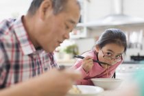 Nonno e nipote mangiare tagliatelle in cucina — Foto stock