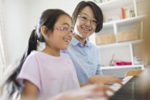 Mother and daughter playing piano — Stock Photo