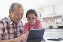 Дедушка и внучка используют цифровой планшет — стоковое фото