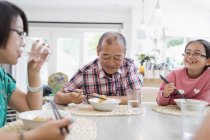 Мульти покоління родини їдять локшину з паличками для їжі за столом — стокове фото