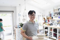 Портрет улыбающийся мужчина моет посуду на кухне — стоковое фото