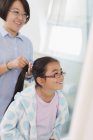 Mother fixing daughters hair in bathroom — Stock Photo