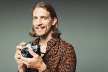 Porträt selbstbewusster junger Mann mit Lenker-Schnurrbart und Retro-Kamera — Stockfoto