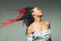 Carefree young woman flipping braids — Stock Photo