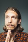 Porträt hoffnungsvoller junger Mann mit Lenker-Schnurrbart betet — Stockfoto