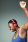 Mujer despreocupada con auriculares bailando, escuchando música - foto de stock