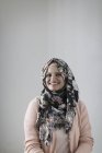 Портрет усміхнений, впевнена жінка в квітковому хіджабі — стокове фото