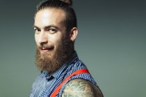 Portrait confident, cool male hipster with beard and shoulder tattoo — Stock Photo