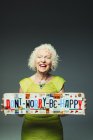 Portrait happy senior woman holding  Dont Worry Be Happy  license plates — Stock Photo