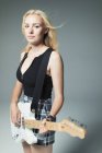 Porträt selbstbewusste, coole junge Frau, die E-Gitarre spielt — Stockfoto