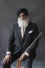 Portrait confident, well-dressed senior man in turban holding flute — Stock Photo