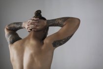 Vista trasera desnudo pecho hipster hombre con tatuajes - foto de stock