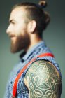 Cierre hombre hipster con tatuaje de hombro y barba - foto de stock