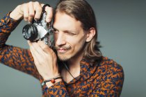 Молодий чоловік з вусами для керма використовує ретро-камеру — стокове фото