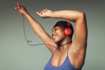 Безтурботний молода жінка з навушниками і mp3 плеєр танцює — стокове фото