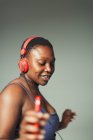 Unbekümmerte junge Frau mit Kopfhörern und mp3-Player tanzt — Stockfoto