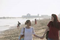 Liebevolles lesbisches Paar hält Händchen am sonnigen Strand — Stockfoto