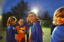 Porträt lächelnde Mädchenfußballmannschaft bei Nacht auf dem Feld — Stockfoto