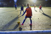 Дівчата футбольної команди практикують на полі вночі — стокове фото