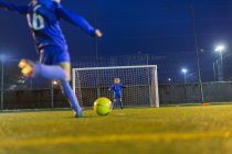 Fußballerin kickt Ball in Richtung Tor — Stockfoto