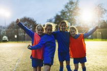 Retrato chicas confiadas equipo de fútbol animando en el campo - foto de stock