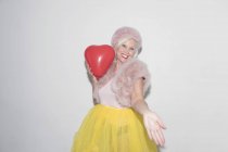 Portrait carefree, playful senior woman with heart-shape balloon — Stock Photo