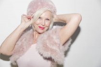 Portrait smiling, elegant senior woman wearing pink fur — Stock Photo