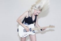 Молода жінка грає на електрогітарі — стокове фото