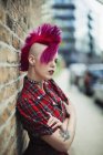 Впевнена молода жінка з рожевим моховиком на міському тротуарі — стокове фото