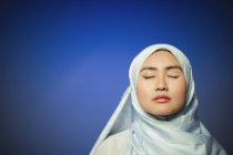 Serene young woman wearing blue silk hijab — Stock Photo