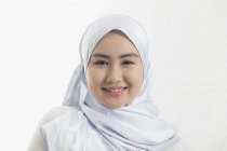 Portrait jeune femme souriante et confiante portant le hijab bleu de soie — Photo de stock