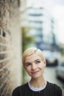 Portrait confident, curious young woman on urban sidewalk — Stock Photo