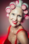 Portrait smiling, confident senior woman with hair in curlers — Stock Photo