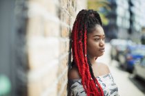 Впевнена молода жінка з червоними косами дивиться на міську вулицю — стокове фото