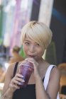 Portrait souriant jeune femme buvant smoothie — Photo de stock