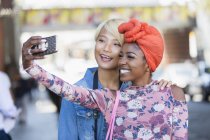 Happy young women taking selfie with camera phone — Stock Photo