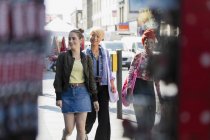 Junge Freundinnen gehen auf städtischem Bürgersteig — Stockfoto
