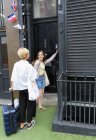 Mujeres jóvenes con maletas que llegan al apartamento de alquiler de casa urbana - foto de stock